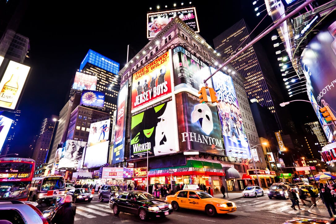 Nighttime picture of Times Square with Broadway plays ads on display.