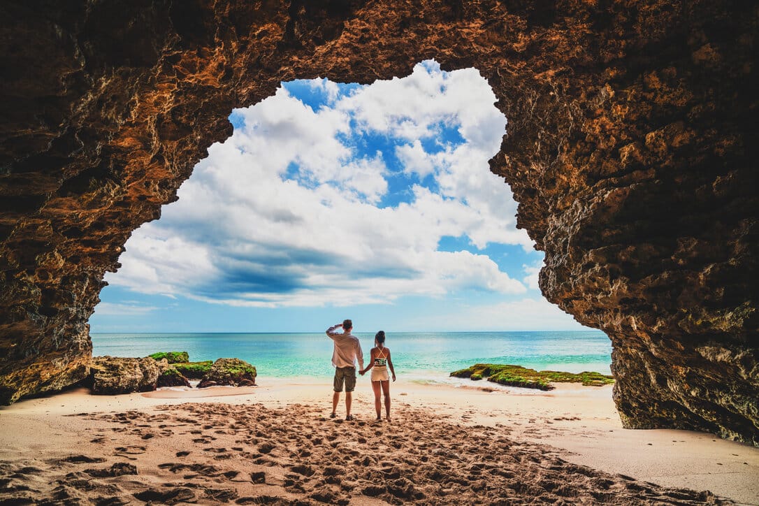 A couple standing in a beach in Oceania.