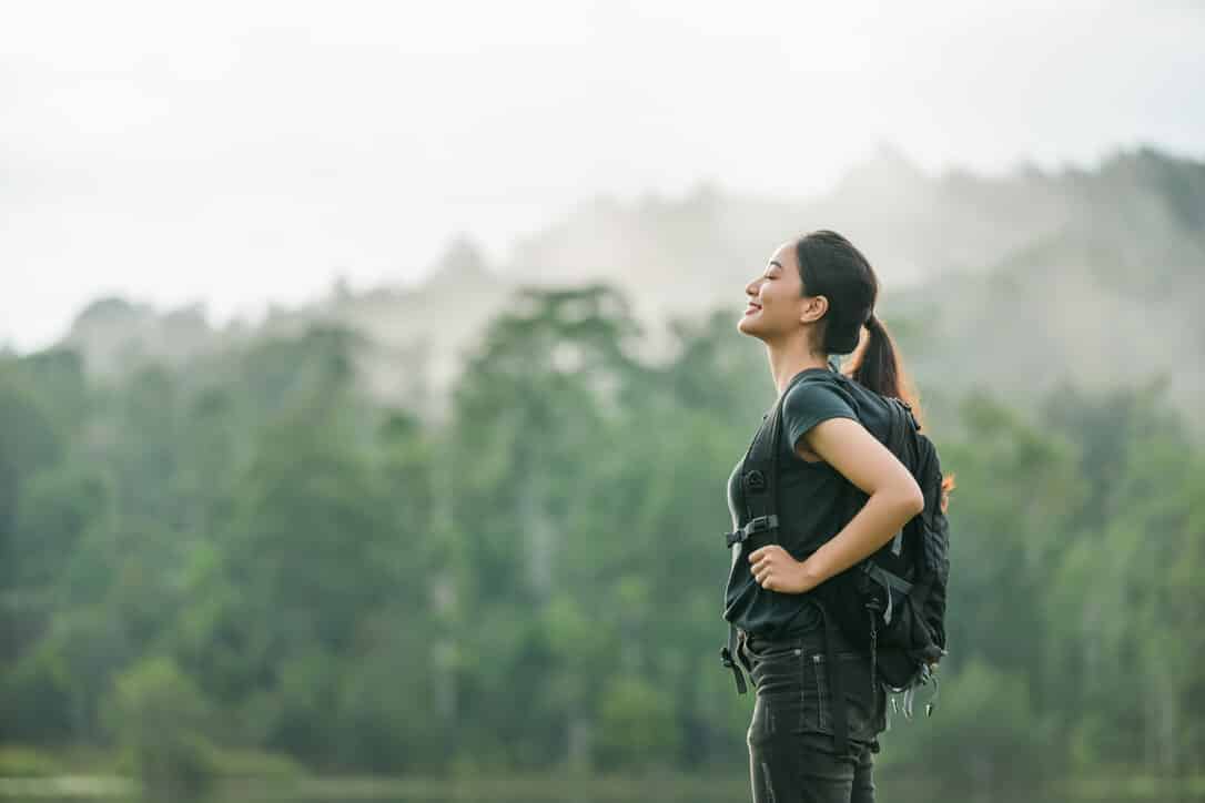 Woman enjoying the fresh air of the mountain after hiking.