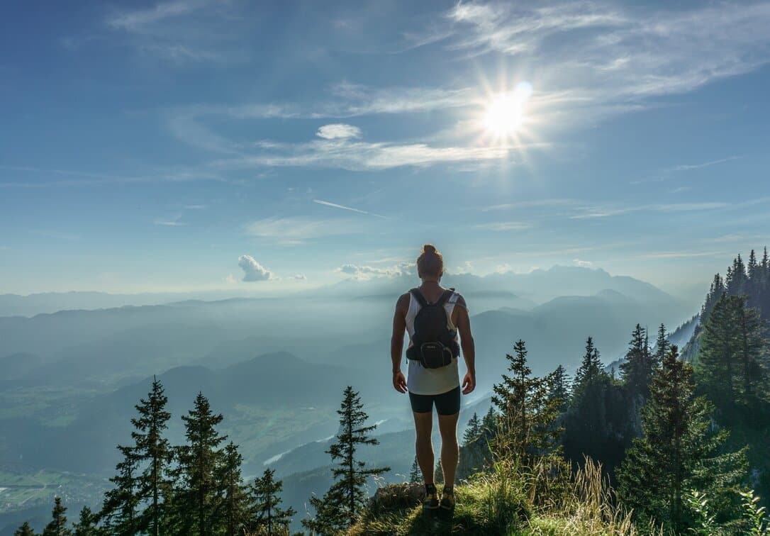 Woman on top of a mountain admiring the landscape