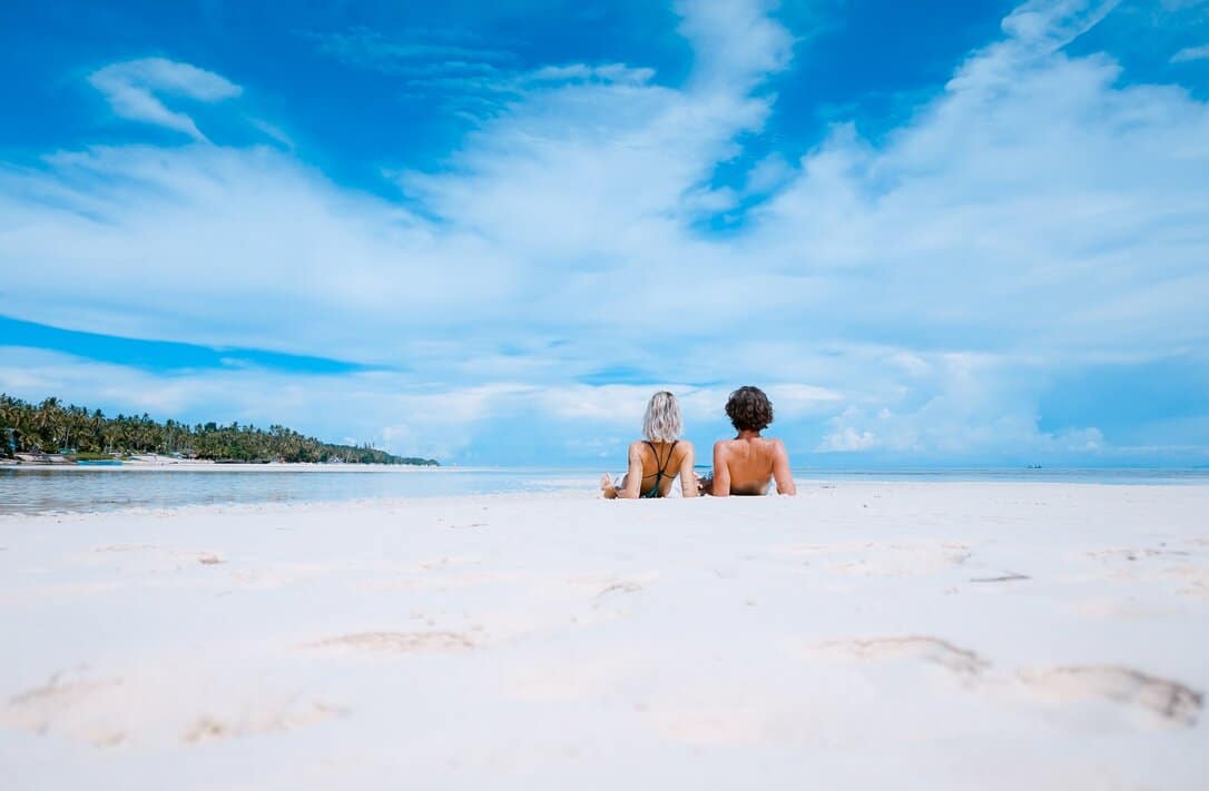 Couple sunbathing at the beach.