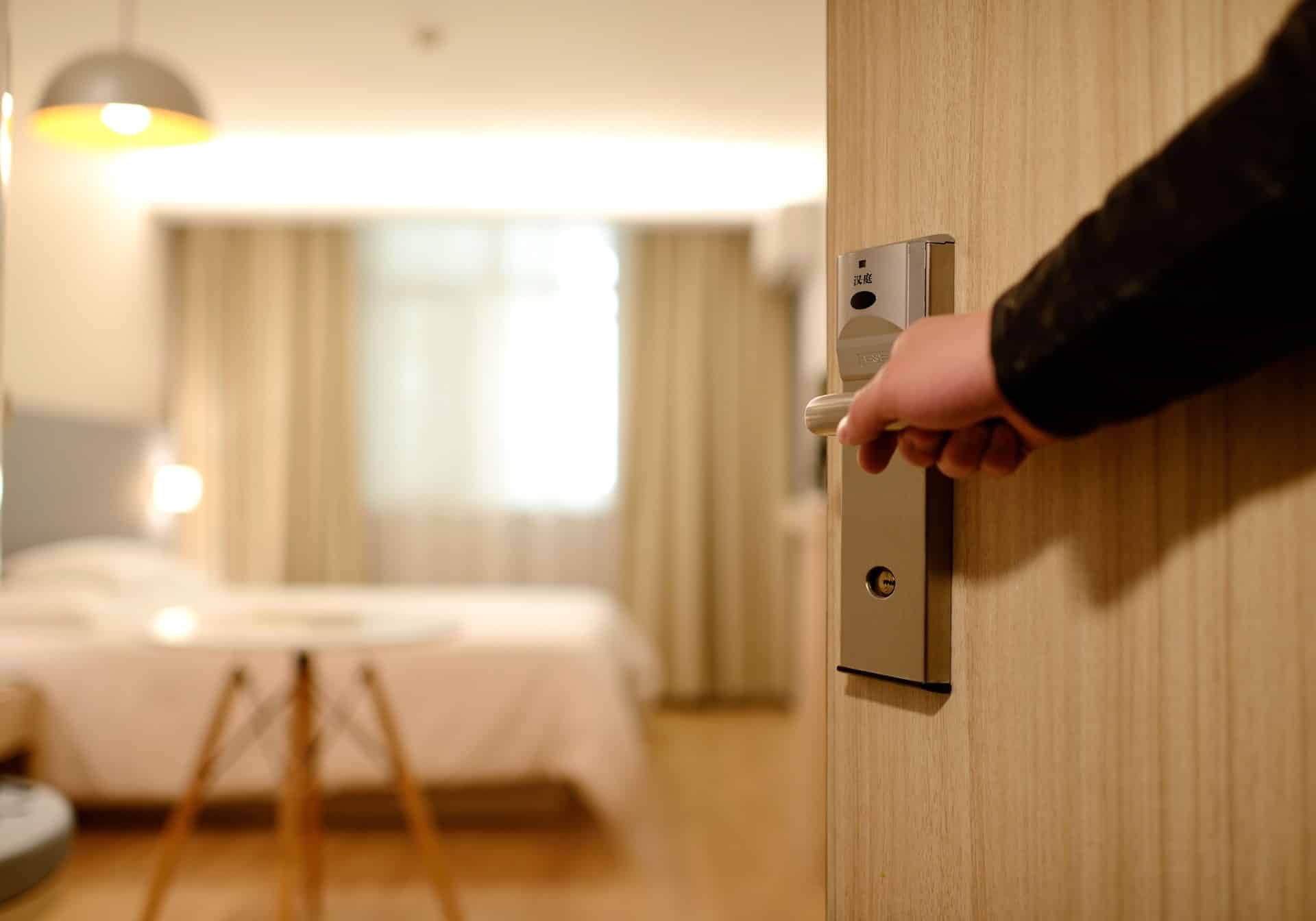 Person holding hotel room door for you.