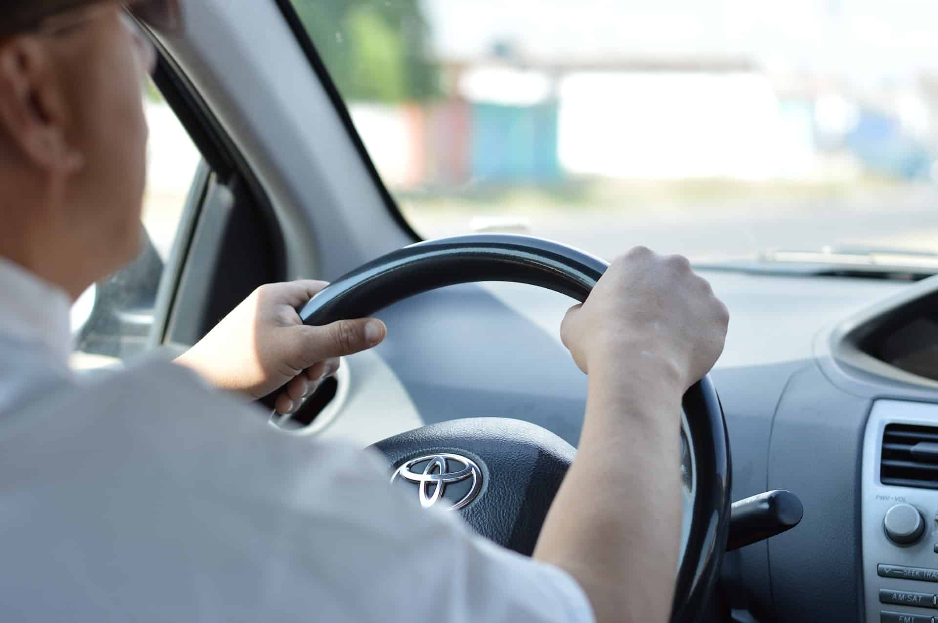 Adult men driving to a drive-thru PCR testing station.