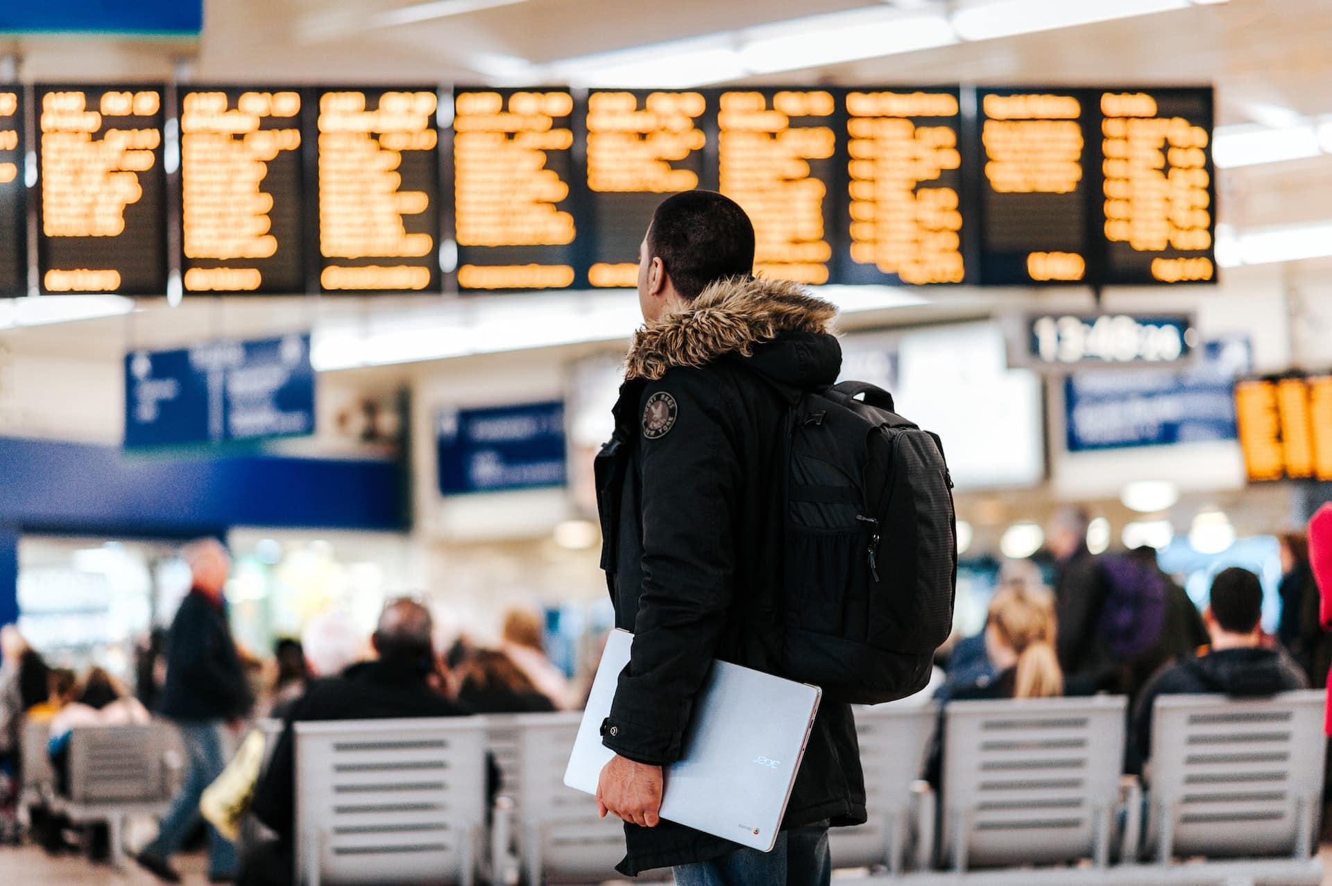 Young men looking at the arrivals and departures board in an european airport.